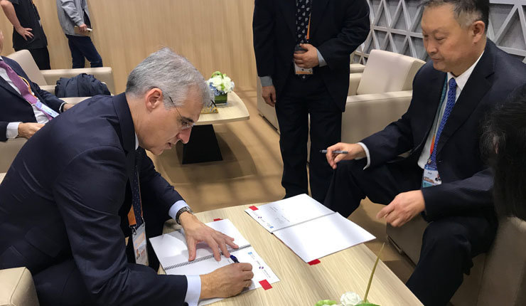 El conselleiro Francisco Conde firmando un memorándum de colaboración con el presidente de la da Cámara de Comercio para a Importación e Exportación de Maquinaria e Produtos Electrónicos de China, Zhang Yujing.