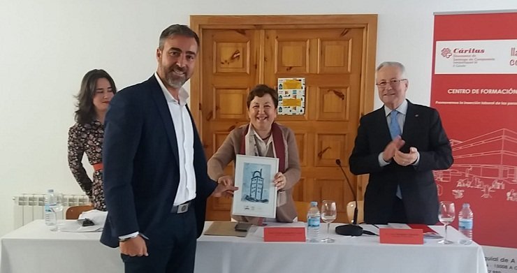 La directora de Cáritas Interparroquial de A Coruña, Pilar Farjas, entrega un diploma de reconocimiento al presidente de la patronal constructora, Diego Vázquez Reino.