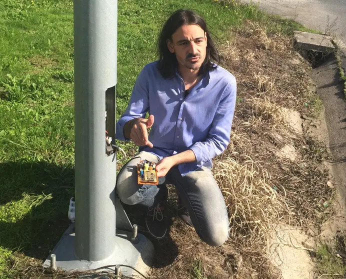 Marcos Balboa enseña el dispositivo de Acute Cable instalado en una farola.