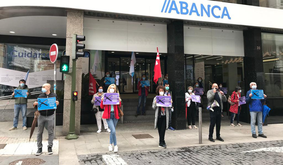 Delegados da CIG protestan diante da oficina de Abanca na rúa Nova da Coruña.